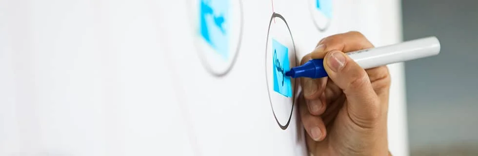 A hand holding a blue marker